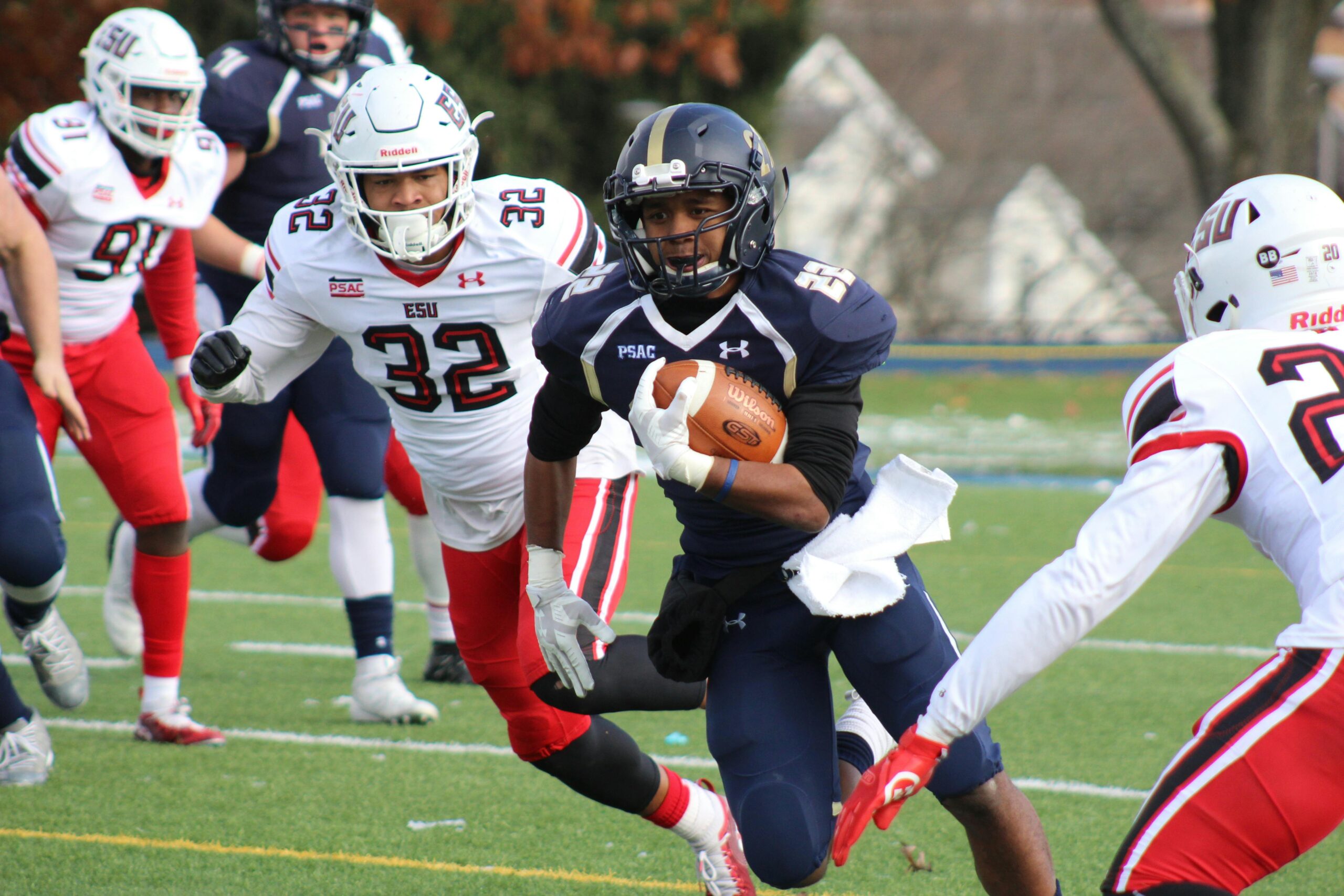 Dynamic college football match with players in action, showcasing athleticism and teamwork on the field.